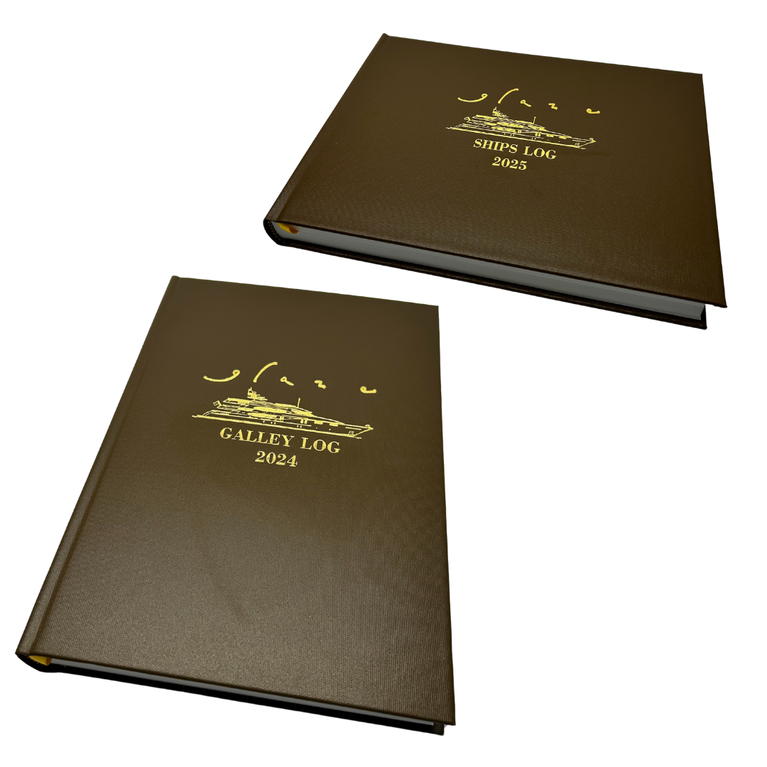 Two custom log books, both featuring a gold design on a rich brown cover with a ribbon bookmark.