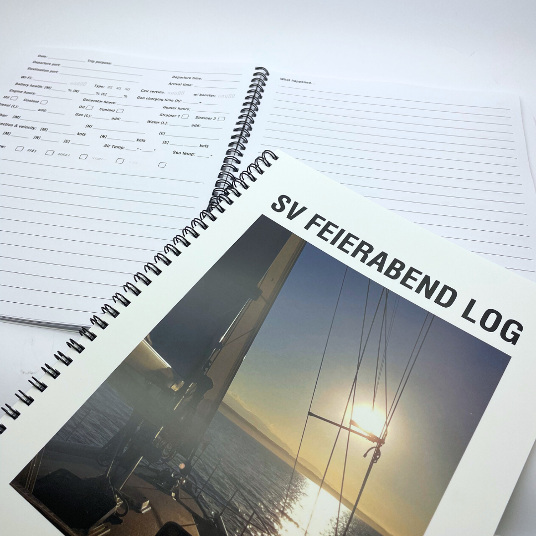 A spiral-bound logbook featuring a cover image of a sunset over water.