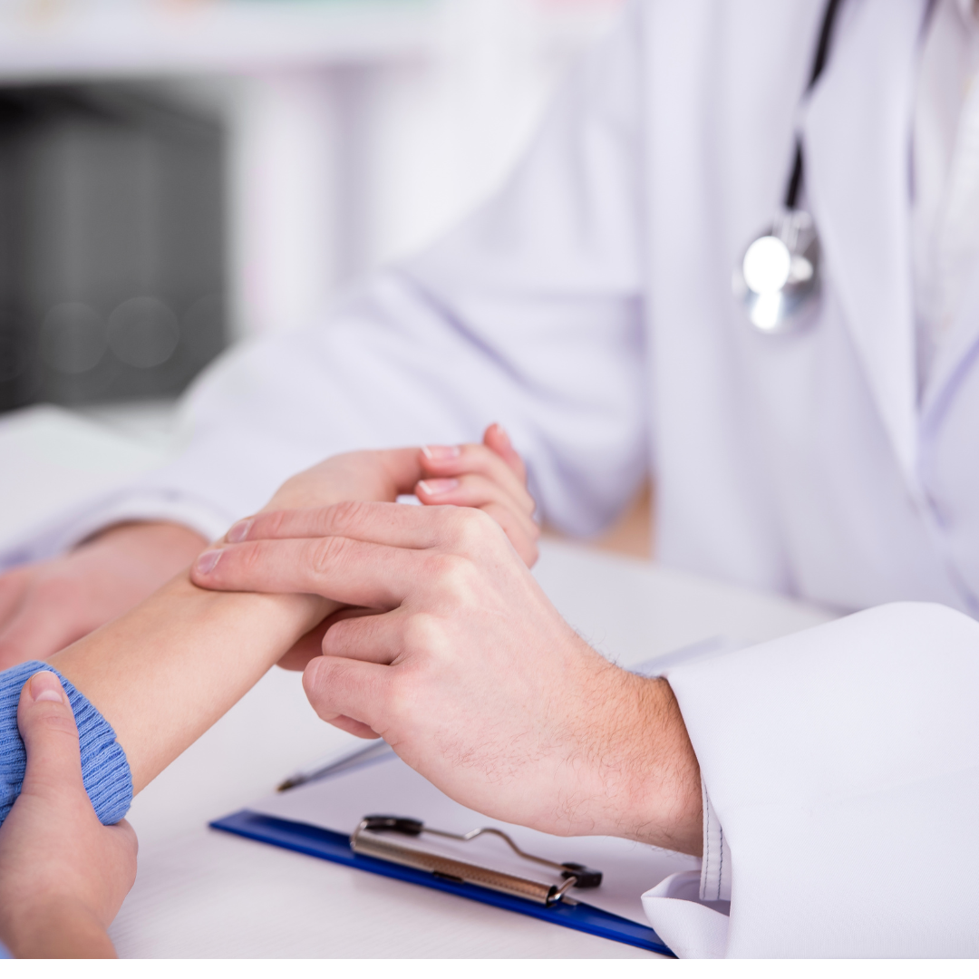 The image shows a medical professional in a white coat examining a patient's wrist.
