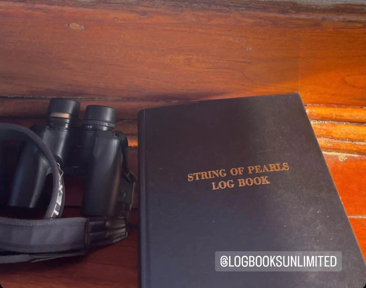 A black log book with the gold text 'String of Pearls Log Book'.