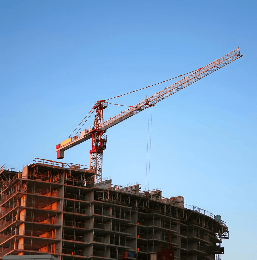 A large red crane towering over a building in development