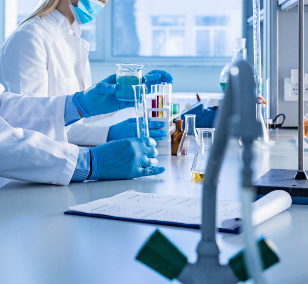 Lab technicians mixing different liquids in test tubes