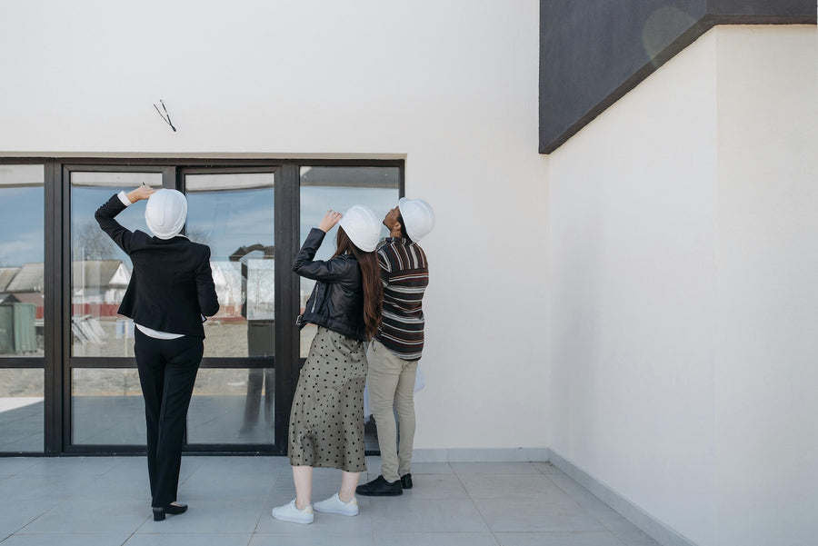 People inspecting the outside of a white building.