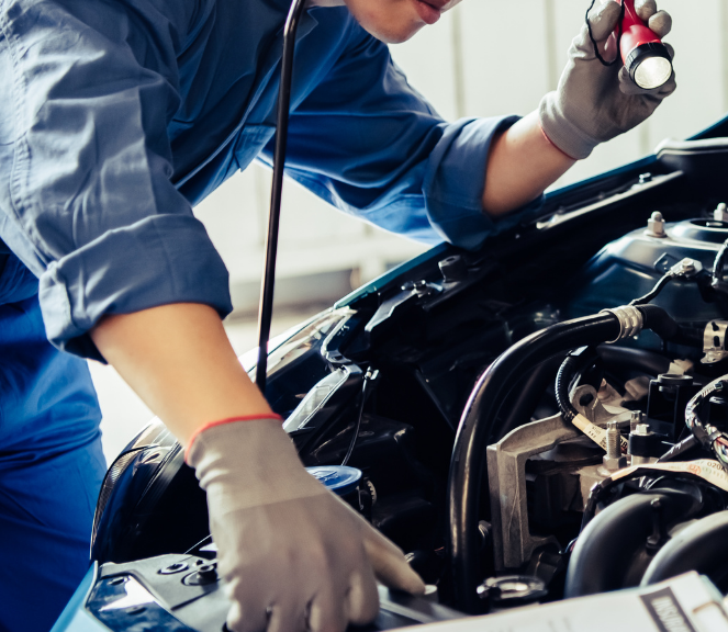 a mechanic inspecting an engine with the hood up
