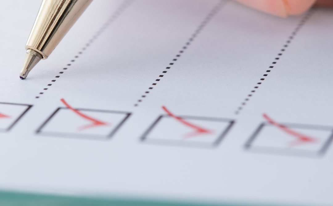Close-up of a pen marking checkboxes on a printed checklist form.